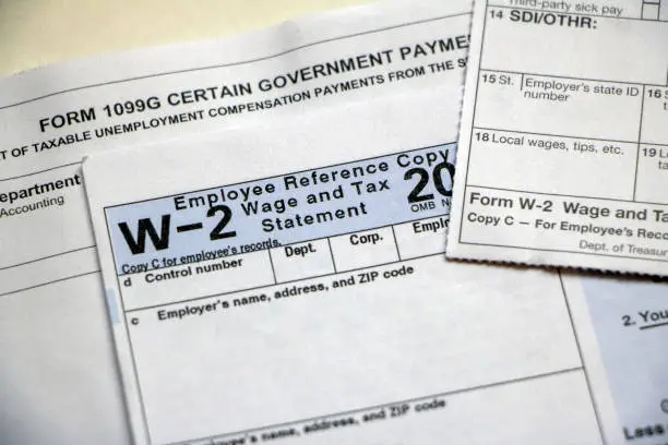 Closeup of tax forms 1099G Certain Government Payments, W-2 Wages, with blank boxes.