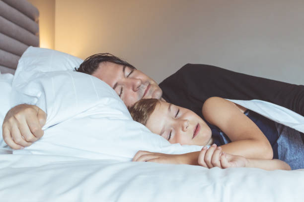 istock Father and son sleeping on the bed. 1193457542