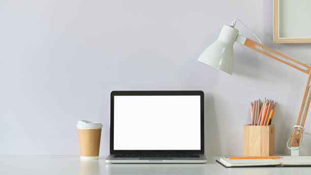 istock Workspace laptop computer, coffee, pencil, photo frame with lamp on white table. 1193457602