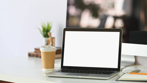 istock Mockup laptop computer and coffee paper cup on workspace with depth of filed. 1193457629