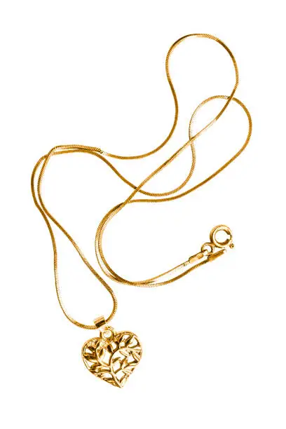 Gold necklace with heart shaped pendant on white background