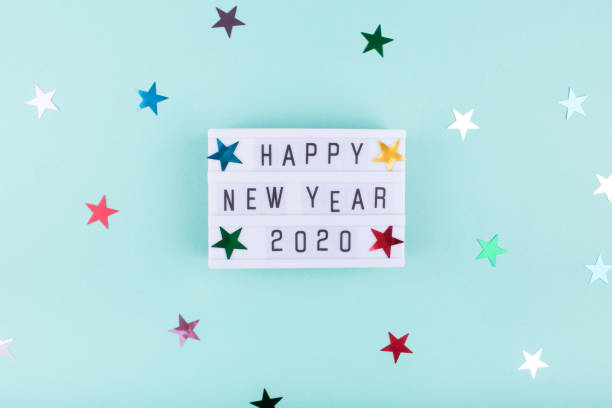 istock Light board with text HAPPY NEW YEAR 2020 on mint color background with stars. 1193464908