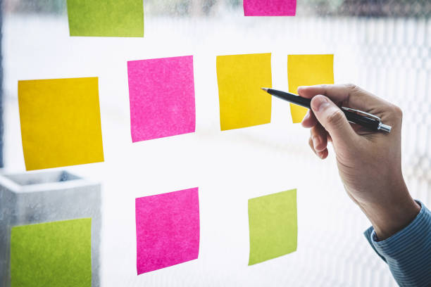 istock Businessman use post it notes to planning idea and business marketing strategy, Sticky note on glass wall 1193466414