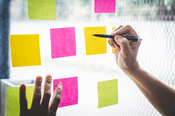istock Businessman use post it notes to planning idea and business marketing strategy, Sticky note on glass wall 1193466417