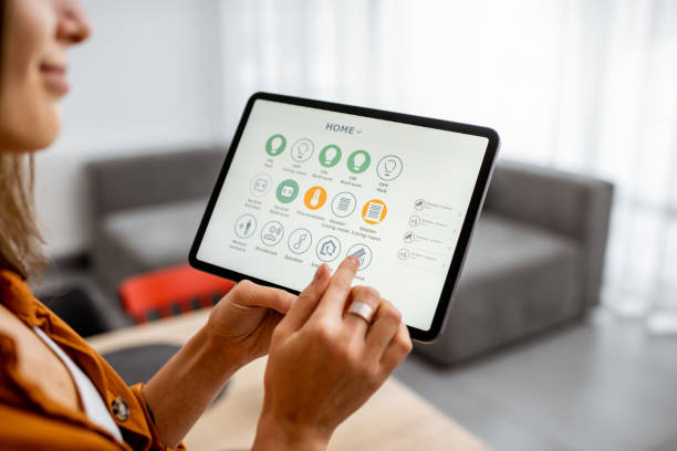 istock Woman controlling smart devices with a digital tablet at home 1193467330