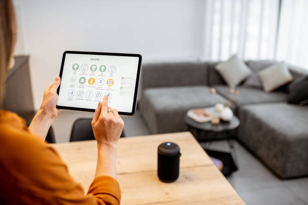 istock Woman controlling smart devices with a digital tablet at home 1193467331