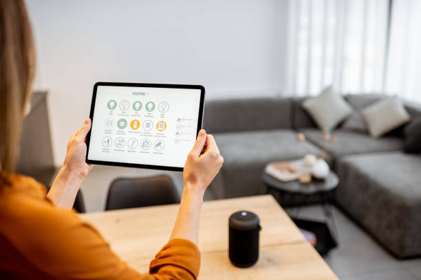istock Woman controlling smart devices with a digital tablet at home 1193467333