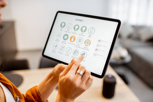 istock Woman controlling smart devices with a digital tablet at home 1193467335