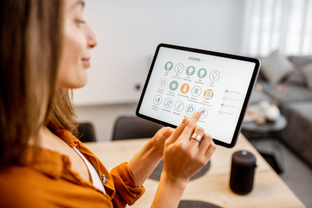 istock Woman controlling smart devices with a digital tablet at home 1193467338