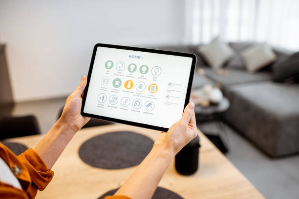 istock Woman controlling smart devices with a digital tablet at home 1193467343