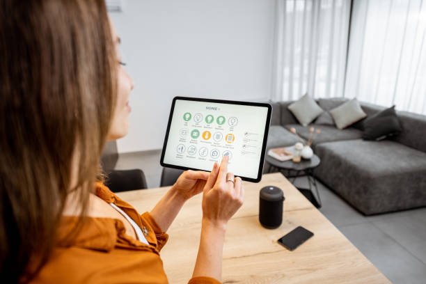 istock Woman controlling smart devices with a digital tablet at home 1193467344