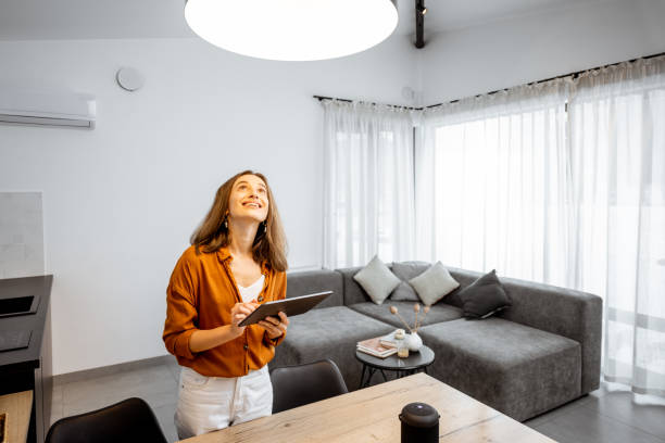 istock Woman controlling light with a digital tablet at home 1193467351