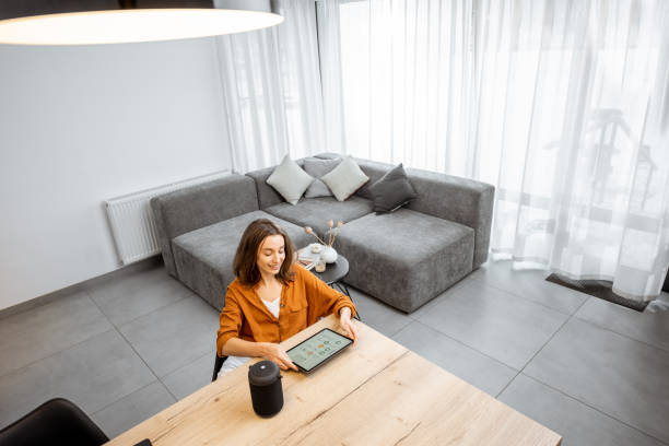 istock Woman with digital devices for smart home control 1193467354