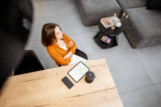 istock Woman with digital devices for smart home control 1193467367