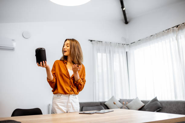 istock Woman controlling home devices with a voice commands 1193467378