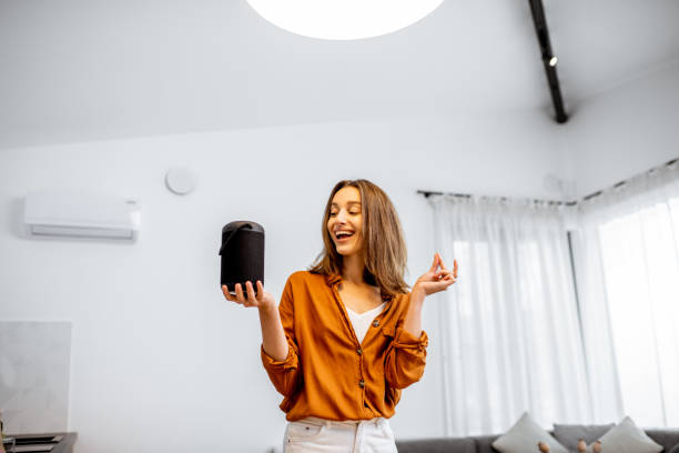 istock Woman controlling home devices with a voice commands 1193467380