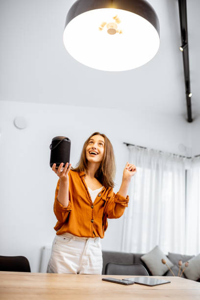 istock Woman controlling light with a smart speaker at home 1193467386