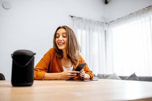 istock Woman controlling home devices with a voice commands 1193467396