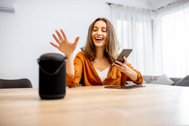 istock Woman controlling home devices with a voice commands 1193467397