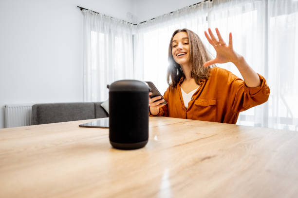 istock Woman controlling home devices with a voice commands 1193467412