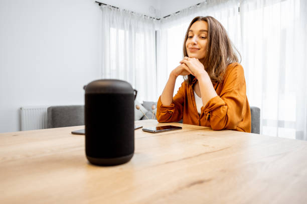 istock Woman with a smart wireless speaker at home 1193467418