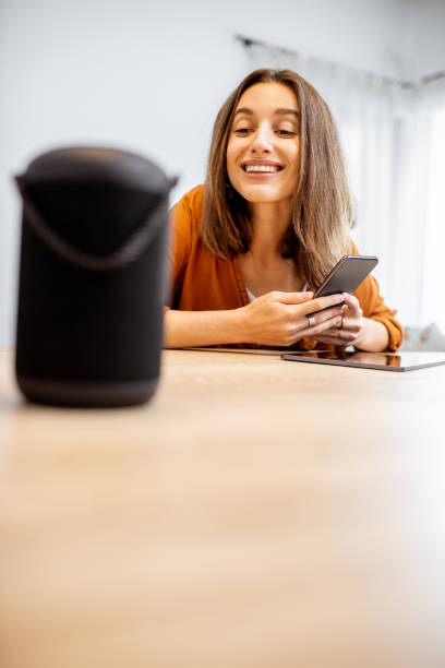 istock Woman controlling home devices with a voice commands 1193467420