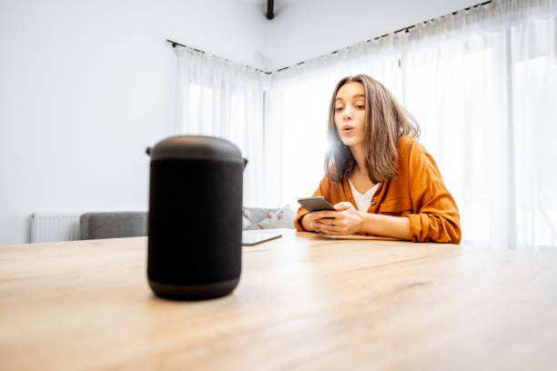 istock Woman controlling home devices with a voice commands 1193467421