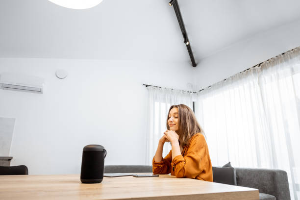 istock Woman with a smart wireless speaker at home 1193467438
