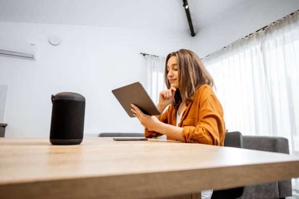 istock Woman with digital devices for smart home control 1193467450