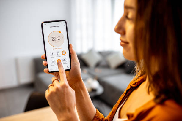 istock Woman controlling heating with a smart phone at home 1193467540