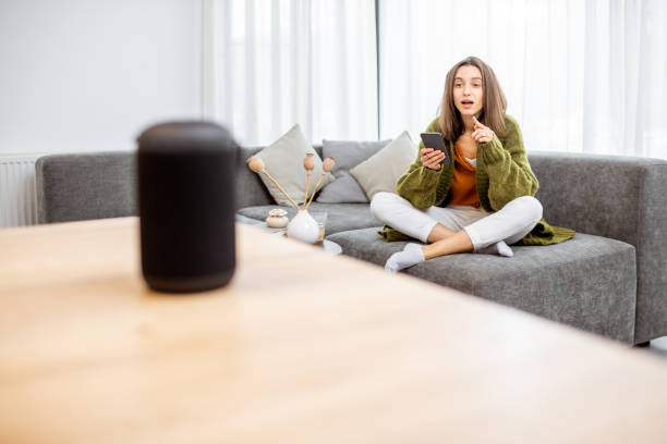 istock Woman controlling home devices with a voice commands 1193468143