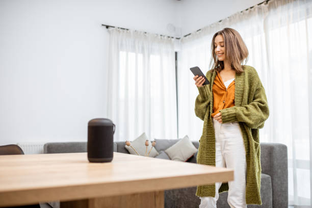 istock Woman controlling home devices with a voice commands 1193468212