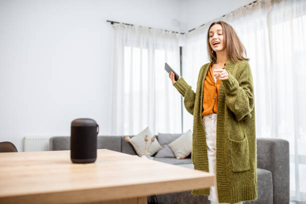 istock Woman controlling home devices with a voice commands 1193468214