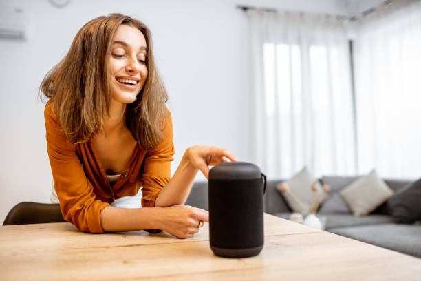 istock Woman with smart wireless column at home 1193468233