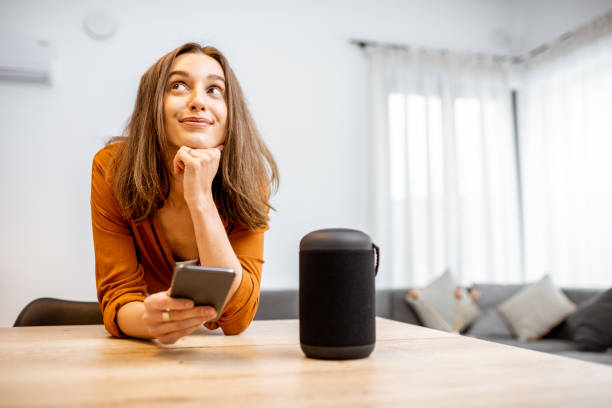 istock Woman with smart wireless column at home 1193468234