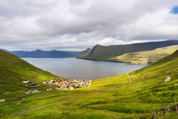 istock Sun light shining through clouds on Gjogv village, Faroe Islands. 1193470618
