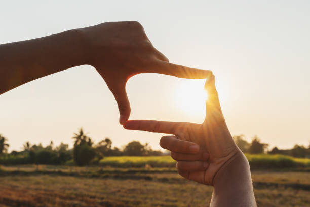 istock closeup hand framing view distant over sunset. business concept 1193472674