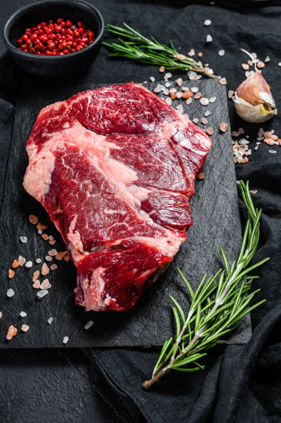 istock Raw beef steak on a chopping Board. Organic farm meat. Black background 1193474202