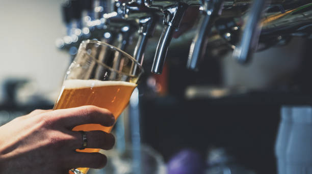 istock bartender hand at beer tap pouring a draught beer in glass serving in a restaurant or pub 1193474204