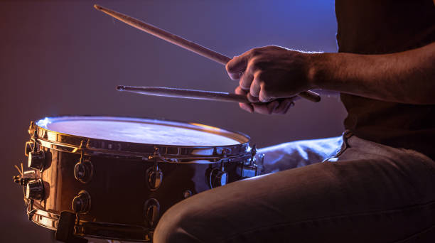 istock man playing the snare drum on a beautiful colored background 1193474479
