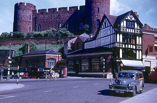 Shrewsbury, Shropshire,West Midlands, England, UK, 1960. Castle at Shrewsbury station: Furthermore: half-timbered houses, shops, cafe, locals and a parked car.