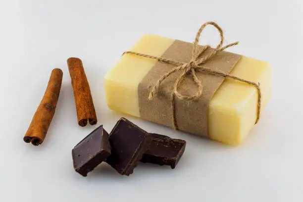 Yellow handmade soap with chocolate and cinnamon on white background.