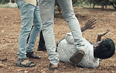 istock Concept of mob lynching - Group of people bullying, kicking a man - Close up of young adult males hitting a person on ground 1193478121