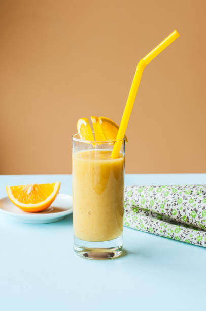 istock Organic banana and orange smoothie on a blue background. 1193483211