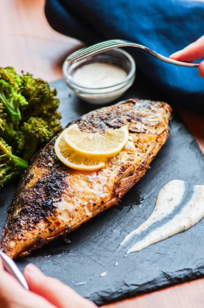 istock Whole roasted dorado fish with broccoli and sauce. 1193483247