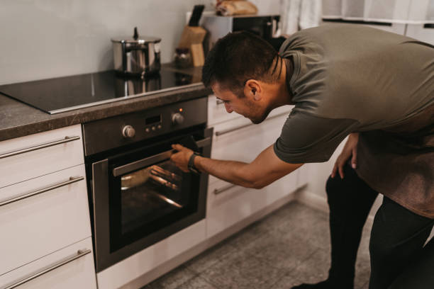 istock Man checking food in the oven 1193484308