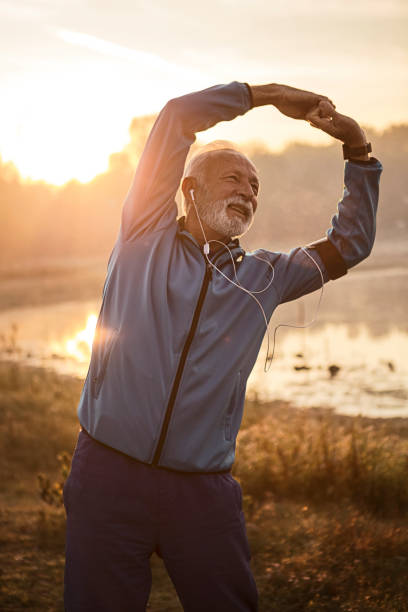 istock Mature man stretching arms getting ready for running near lake 1193484517