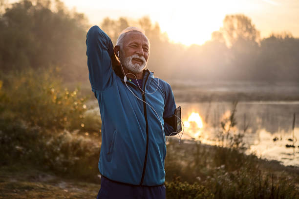 istock Mature man stretching arms getting ready for training near lake 1193484525