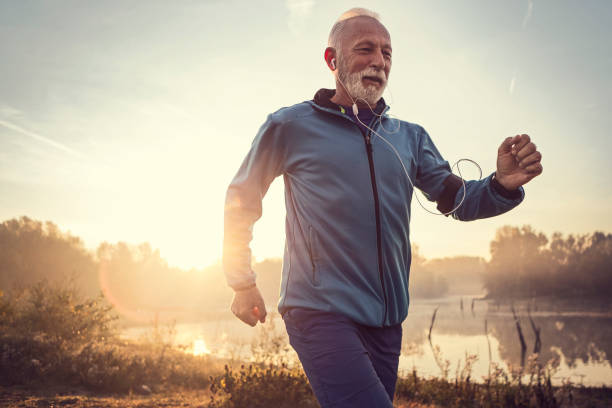 istock Mature man jogging in by lake with first sun 1193484613