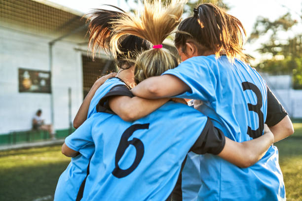 ragazze di calcio che si stringeno dopo la partita vincente - child celebration cheering victory foto e immagini stock